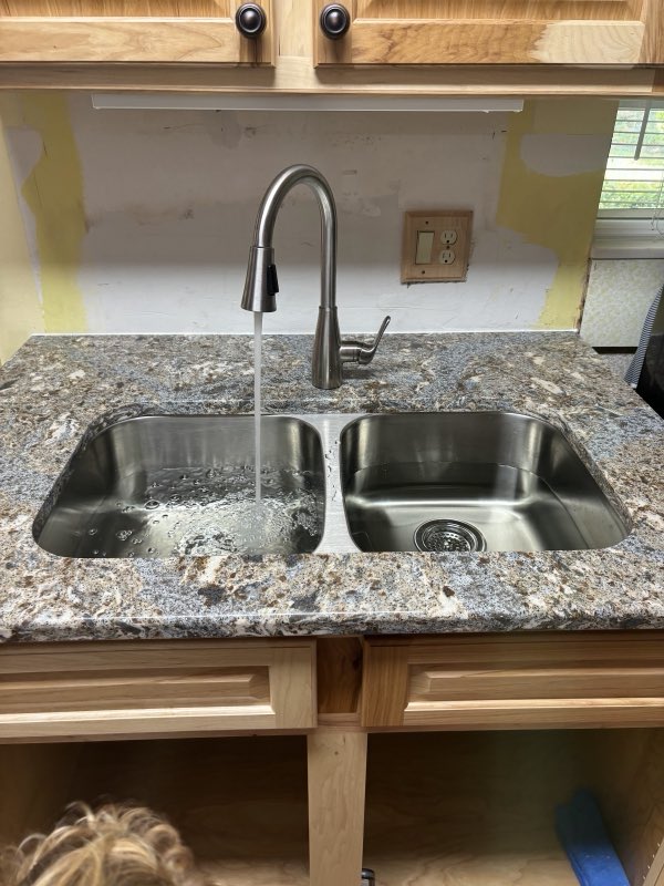 New kitchen sink and faucet installed in a granite countertop